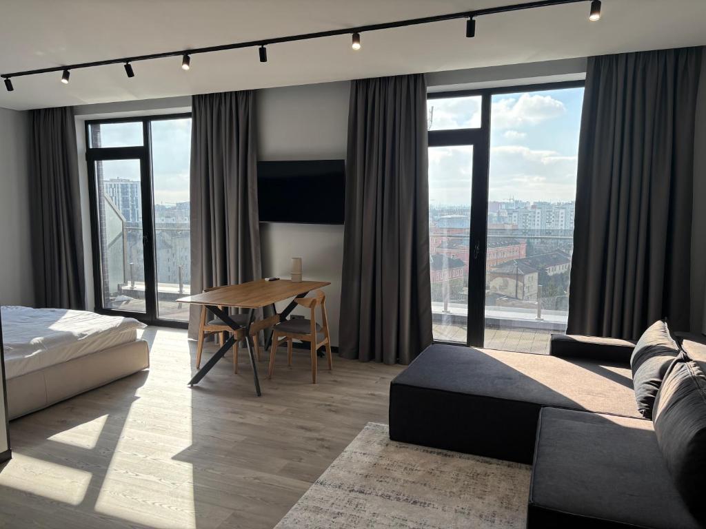 a bedroom with a bed and a table with a view at Bavaro apartments 2 in Ivano-Frankivsk