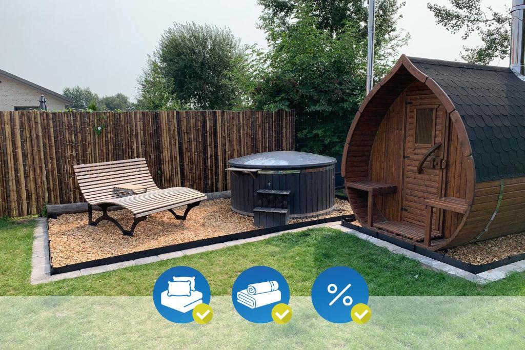 a gazebo with a bench and a trash can at freistehendes Ferienhaus mit Sauna und Badefass in Sehestedt