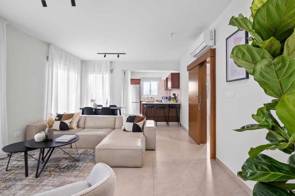 a living room with a couch and a table at Ethereal Residence by Nomads in Paphos