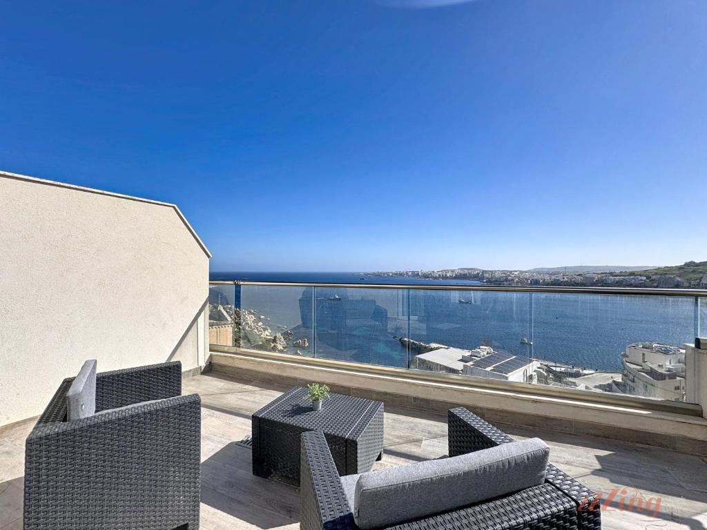 a balcony with chairs and a view of the water at Stylish Seaview Retreat in St Pauls Bay in St. Paul's Bay