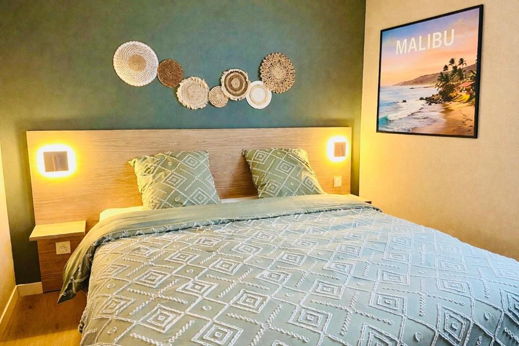a bedroom with a large bed with pillows at Appartement cosy ambiance Malibu dans résidence avec piscine 2 pers 1 chambre in Neuf-Mesnil