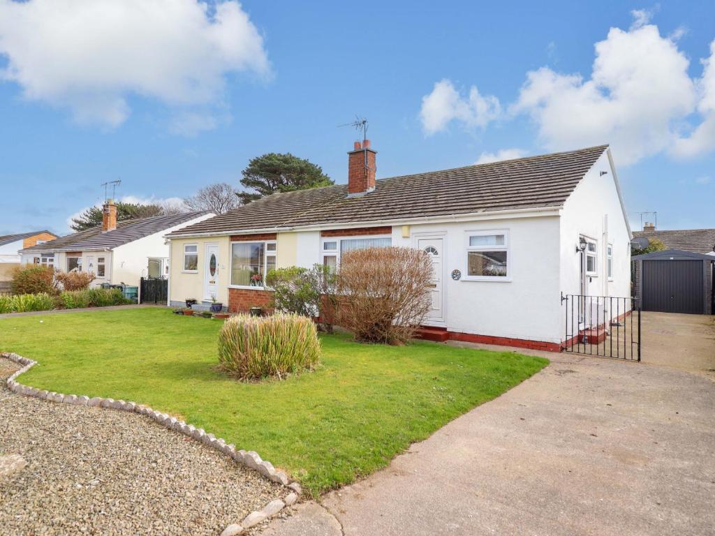 a white house with a yard at Castle Cove in Abergele