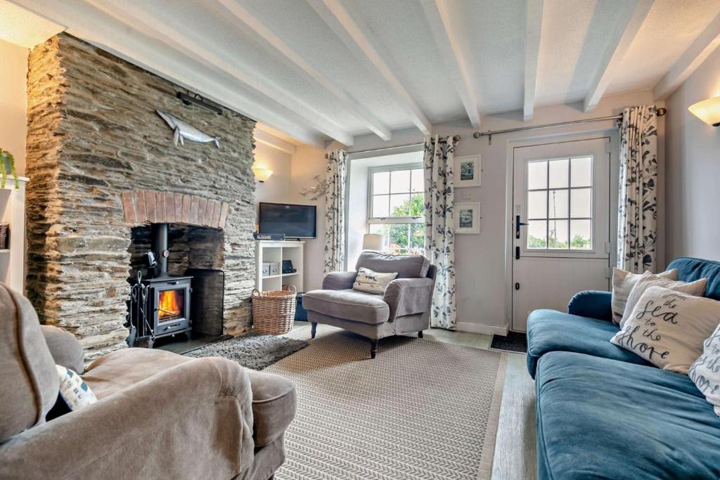 a living room with a couch and a stone fireplace at 2 Bed in Edmonton oc-p00586 in Wadebridge