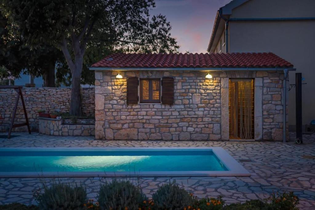a house with a swimming pool in front of a building at Villa Rural wellness in Validžići