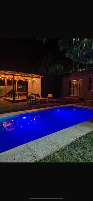 a blue swimming pool in front of a house at night at Casas Villa azul in Tanti