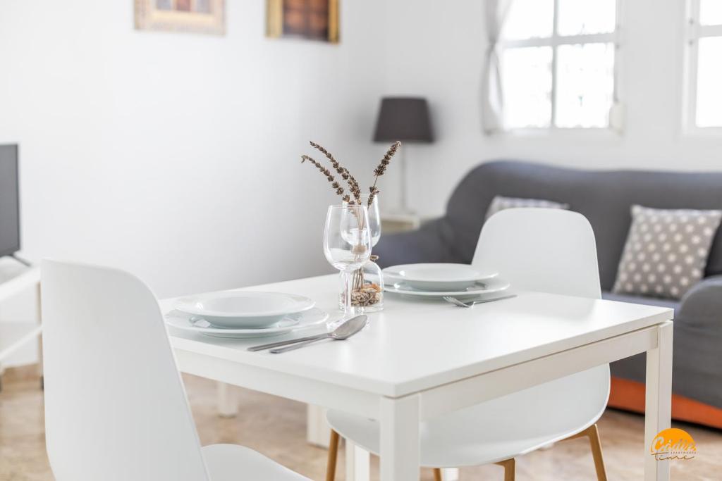 a white dining room table with white chairs at Apartamento Encanto Gaditano con Terraza by Cádiz Time in Cádiz