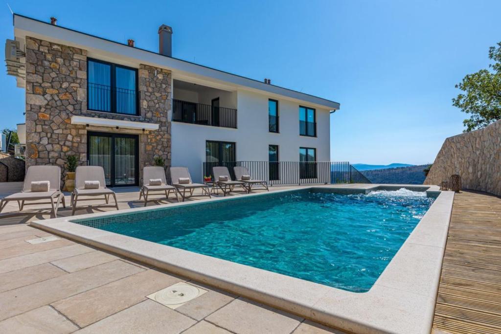 a villa with a swimming pool in front of a house at Villa Jackie in Bribir