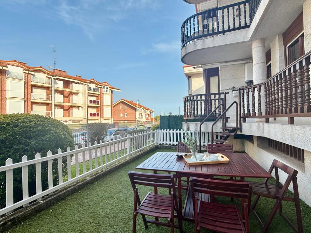 a balcony with a table and chairs on a building at Apartamento en la playa con piscina - Azcona 6004 in Noja