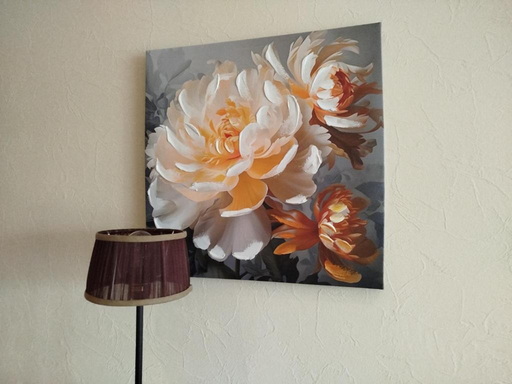 a painting of a flower hanging on a wall at FourSpace in Ventspils