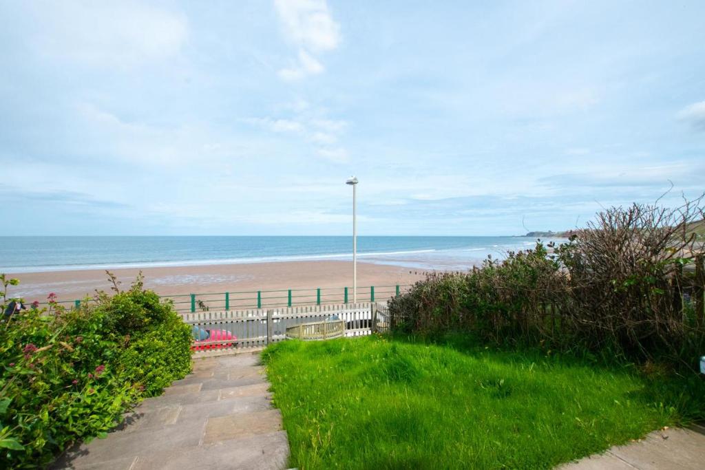 a walkway to a beach with the ocean in the background at 2 Bed in Sandsend oc-wa317 in Sandsend