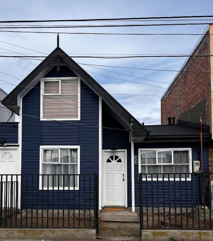 a blue house with a white door at Magnolia Mini House Casa A in Puerto Natales
