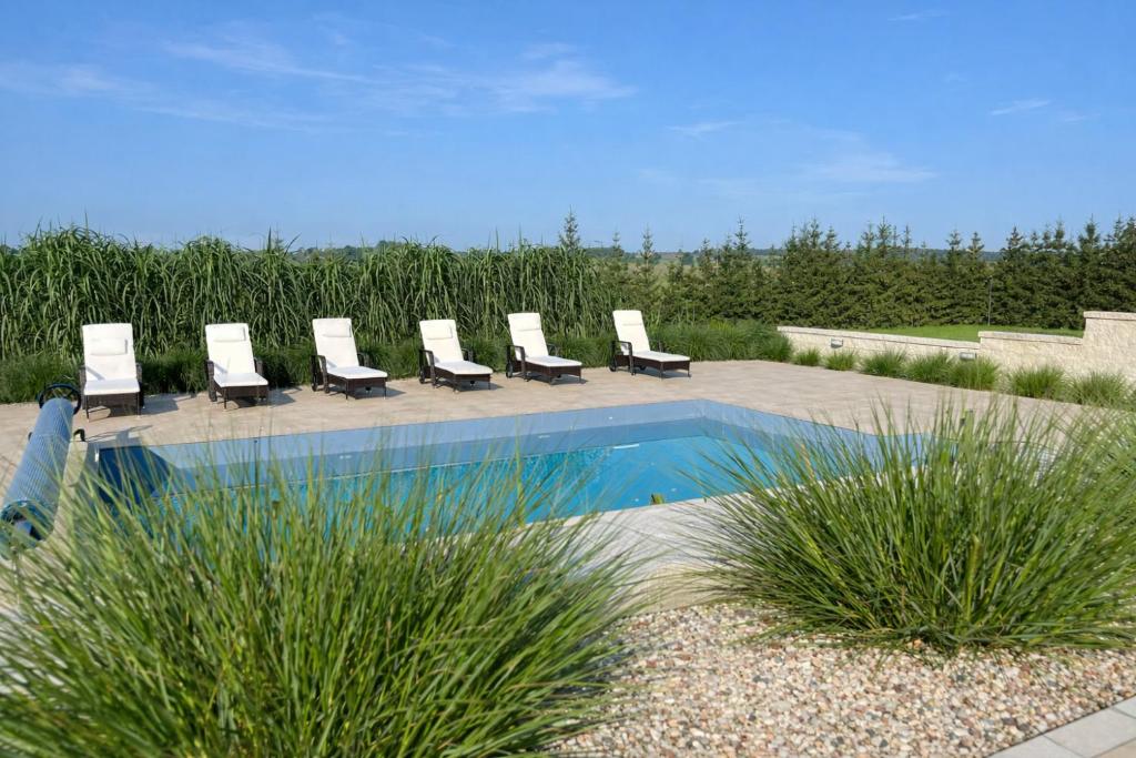 a row of lounge chairs sitting next to a pool at Mazurski Diament koło Mrągowa in Sorkwity
