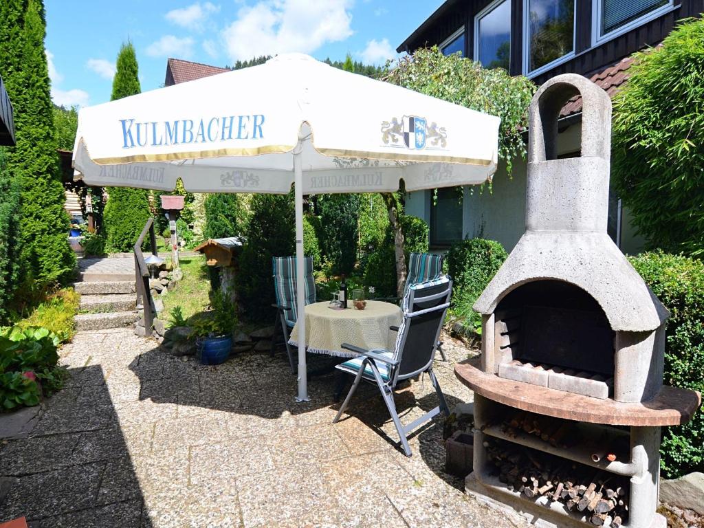 SieberにあるWonderful Apartment in Herzberg ot Sieber with Barbecueの傘、テーブル(屋外オーブン付)