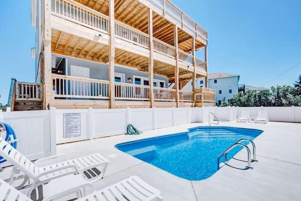 a swimming pool with chairs and a building at Little Cayman in Salvo