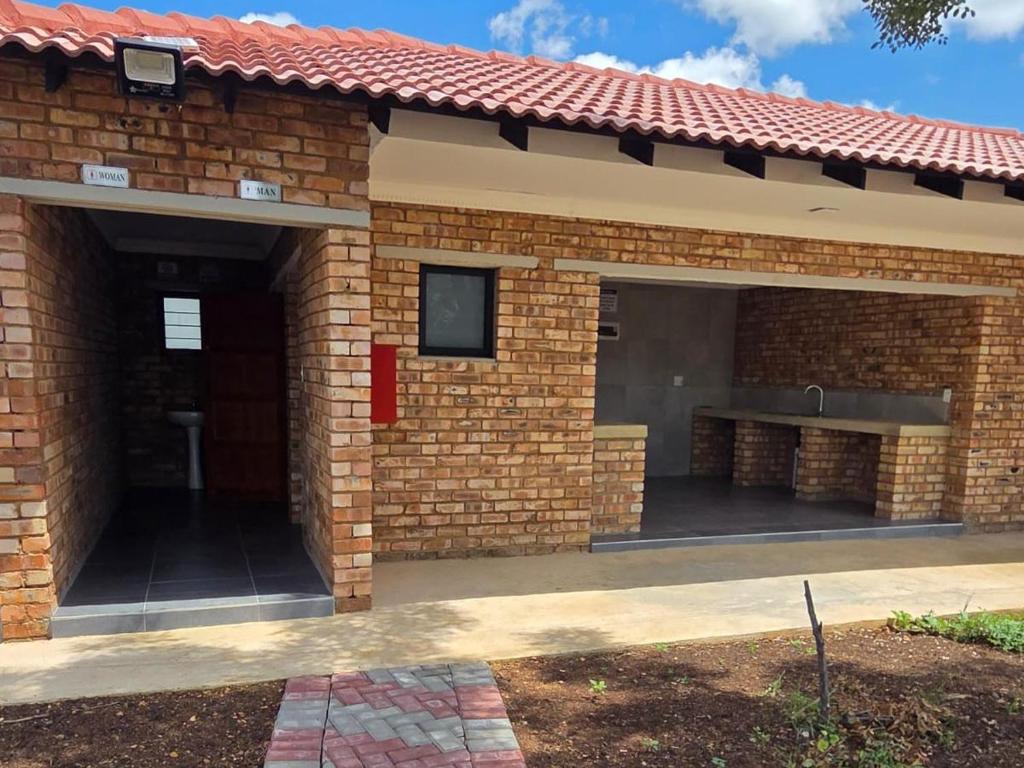 a brick house with a red roof at Bush Diamond Lodge in Cullinan