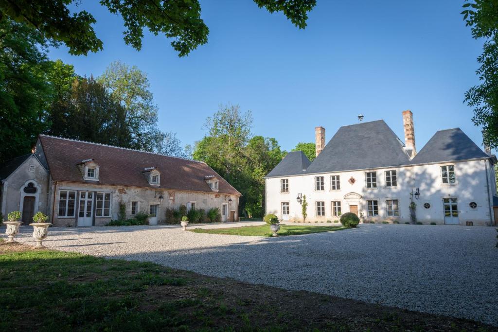 an exterior view of a house with a driveway at La maison des romans du Château du Sollier - Charme Calme Confort Climatisation - à 5mn du péage de Bourges à la campagne - stationnement privé -Panette Collection in Bourges