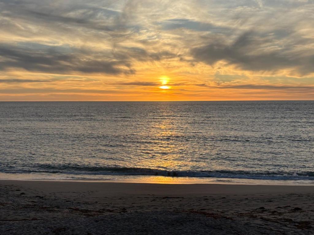 a sunset on the beach with the sun setting at Moledo Seaview in Moledo
