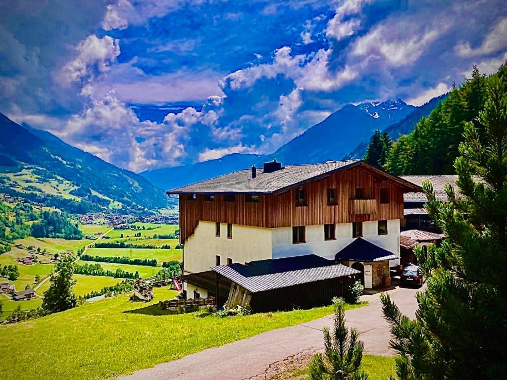 a barn in a field with mountains in the background at Ferienwohnung Oberprossegg in Matrei in Osttirol