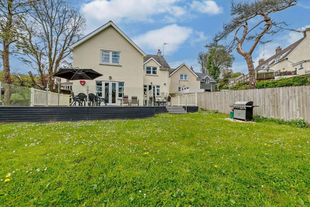 a white house with an umbrella in a yard at 4 Bed in Tenby oc-t27576 in Tenby