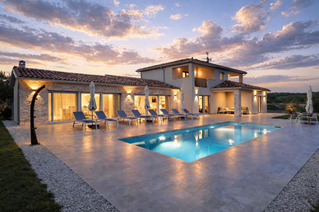 a villa with a swimming pool in front of a house at Villa Juki by Briskva in Kaštel