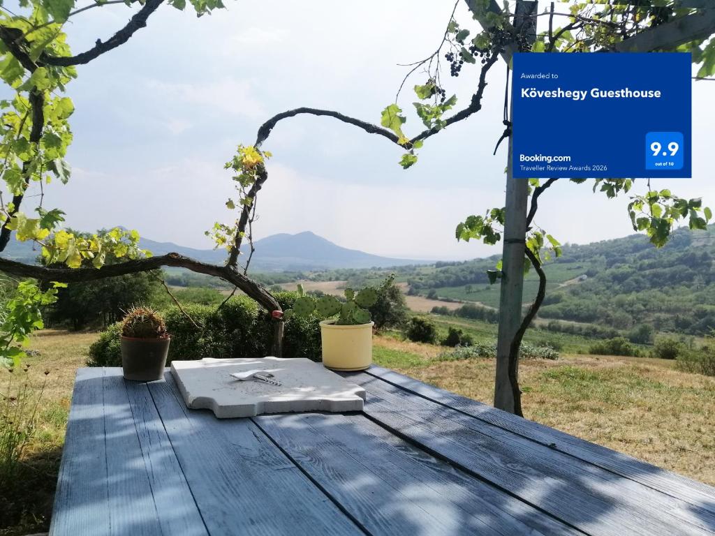 a picnic table with a sign with a view at Köveshegy Guesthouse in Tapolca