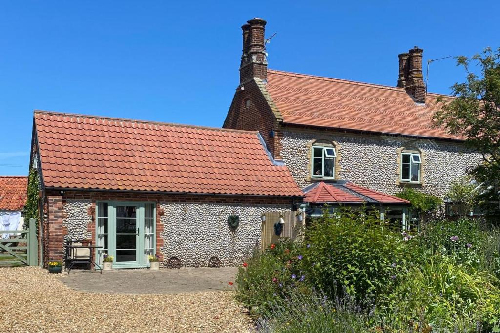 an old brick house with a red roof at 2 Bed in Bodham oc-m15008 in Bodham
