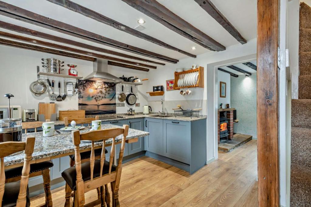 a kitchen with blue cabinets and wooden beams at 2 Bed in Bodham oc-t27775 in Bodham