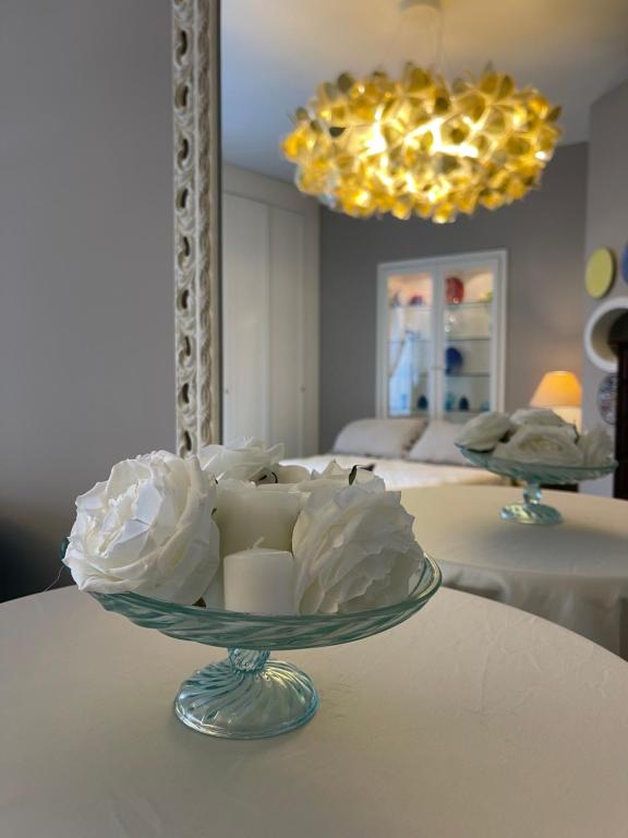 a glass bowl with white flowers on a table at Casa Mariannina in Maiori