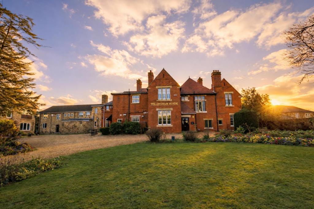 an old brick house with a yard in front of it at Willingham House Hotel in Willingham