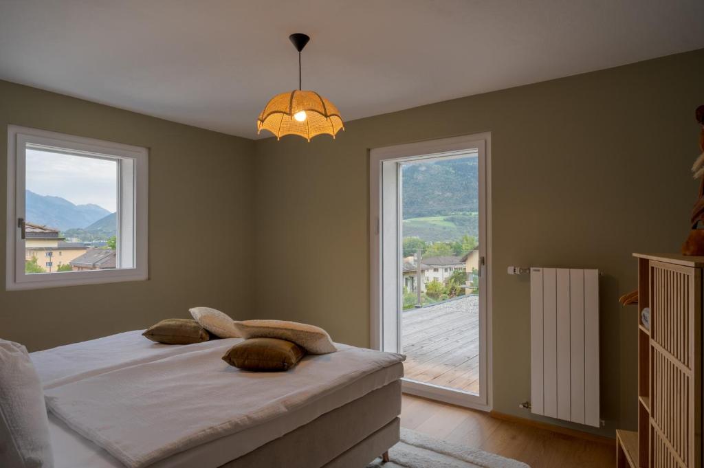 a bedroom with a bed and a large window at Chambres d'hôtes Les Vergers in Chalais