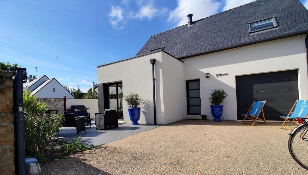 a white house with blue chairs and a garage at Ty Laouen Gite Quiberon in Quiberon