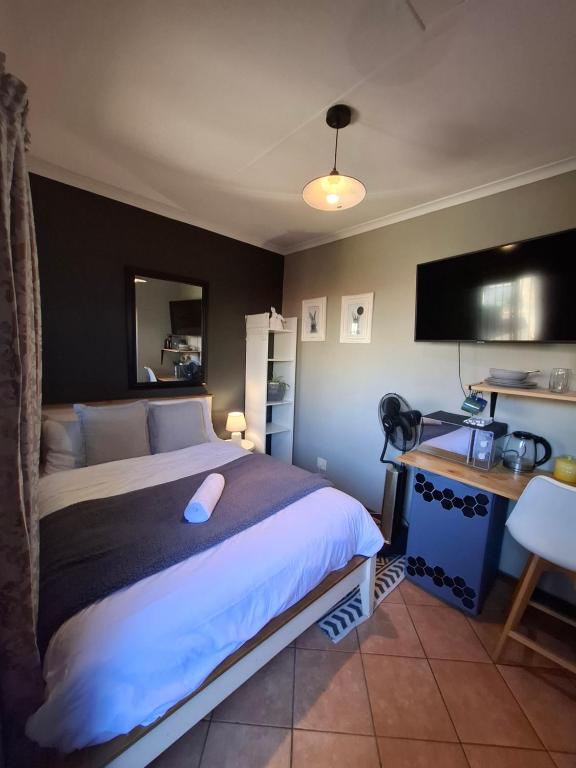 a bedroom with a bed and a desk with a computer at Cozy City Studio Escape in Centurion