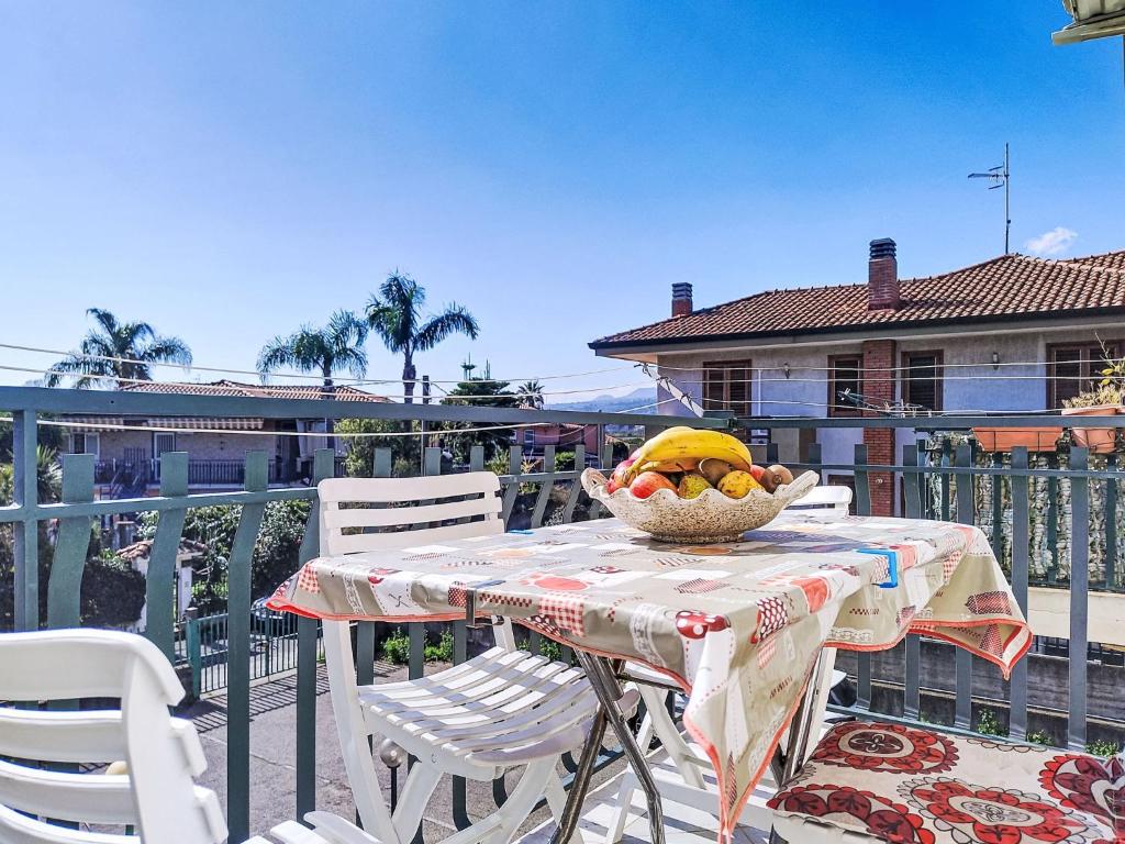 a table with a bowl of fruit on a balcony at Apartment Clara by Interhome in Fondachello