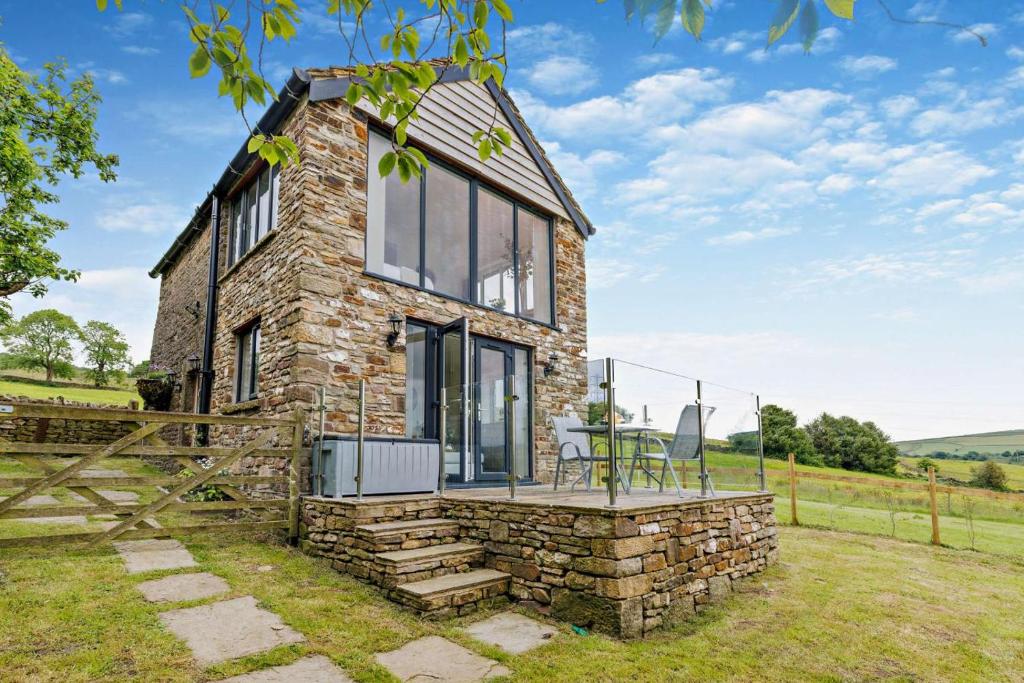 a stone house with a large window on a field at 1 Bed in New Mills oc-p29603 in Mellor