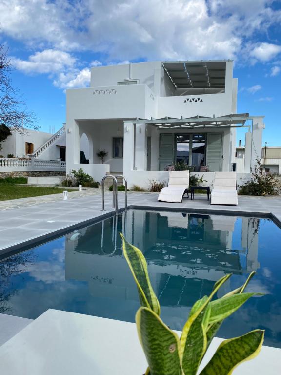 a house with a swimming pool in front of it at Zandre Luxury Suites in Skiros