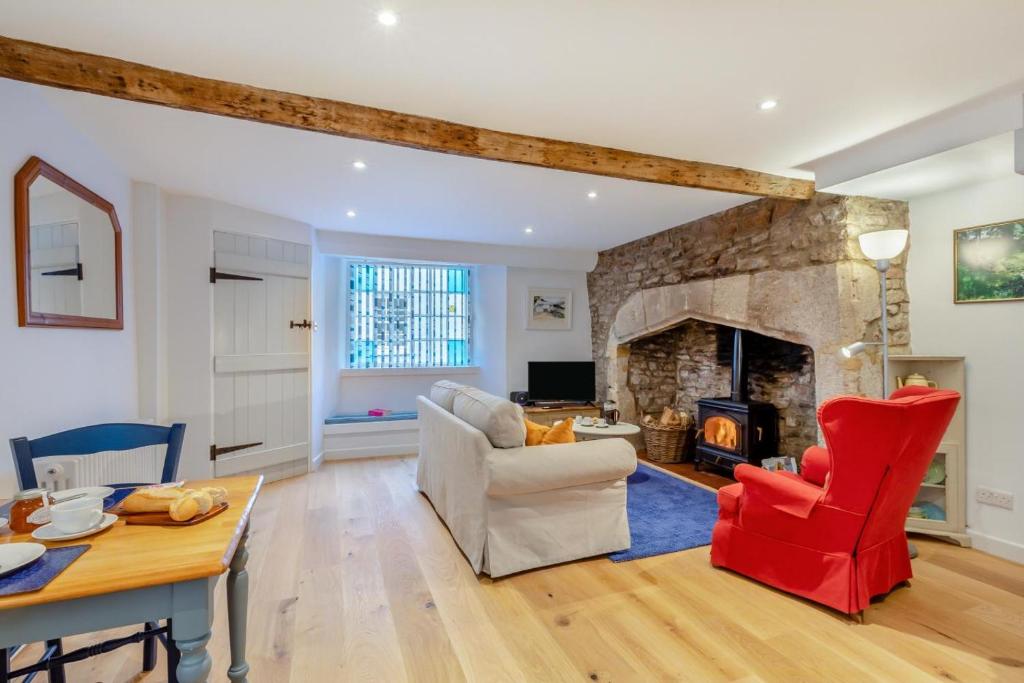 a living room with a stone fireplace and red chairs at 1 Bed in Wells oc-h30450 in Wells