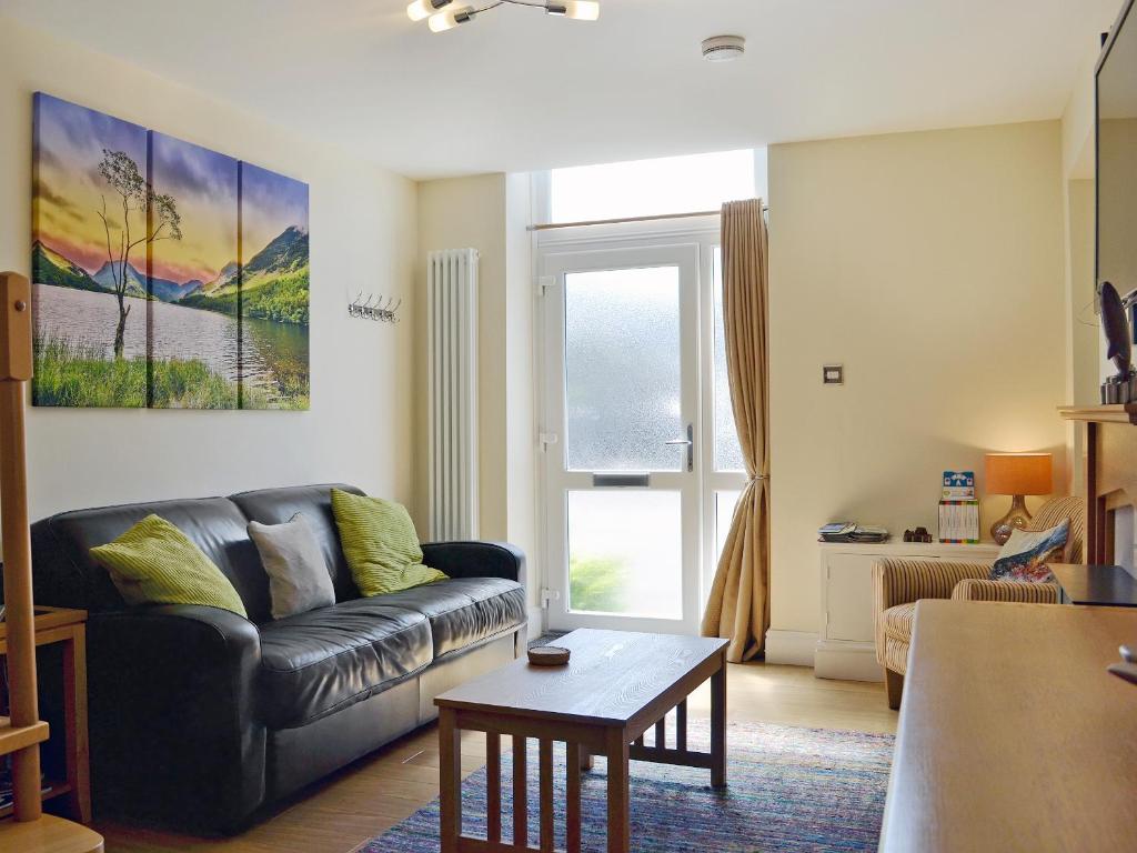 a living room with a couch and a table at Ghillie Cottage in Cockermouth