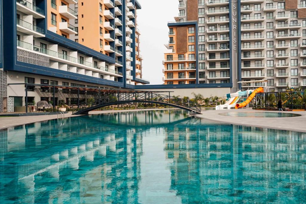 a swimming pool in a city with tall buildings at Riverside Life Residence in Trikomo