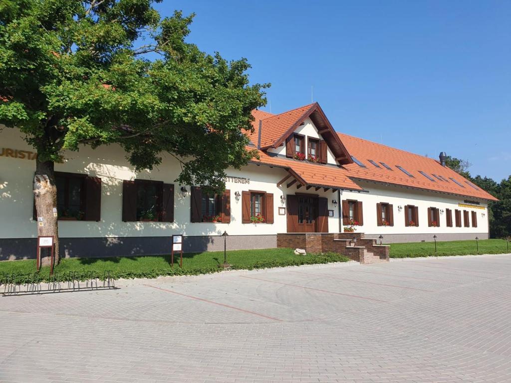 a building with a tree in front of it at Esterházy Fogadó in Gánt