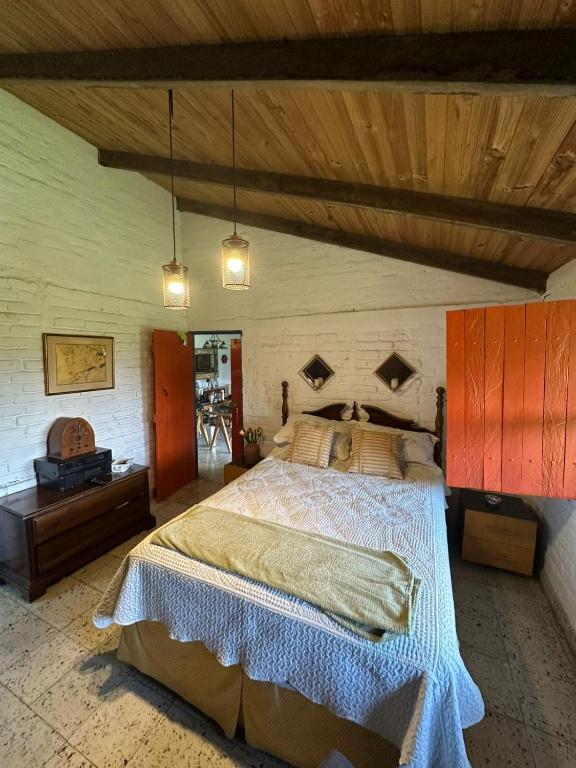 a bedroom with a large bed and a wooden ceiling at Ingenia Casa Hostal in Palmira