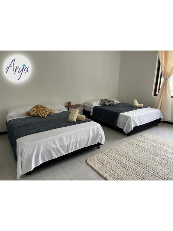 two beds in a room with two rug at Arya Land Yoga Hostel in Cali