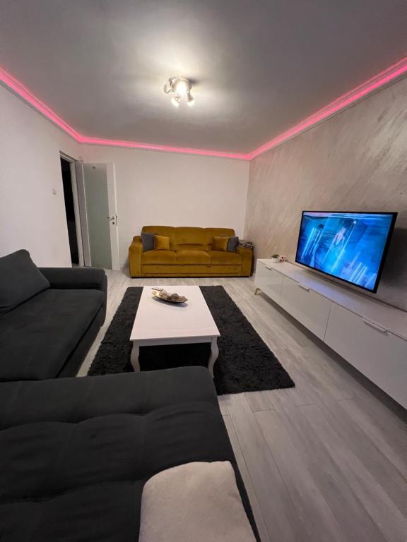 a living room with a couch and a flat screen tv at city apartament in Oradea