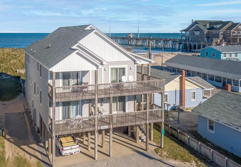 an aerial view of a house with a pier at Paradise Found - Nags Head MP 16.5, Oceanfront, Ocean & Sound Views, Pool, Hot Tub, Pets OK in Nags Head