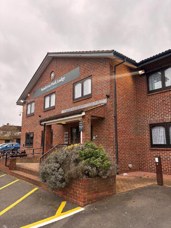 a red brick building with a sign on it at Sandown Park Lodge in Esher