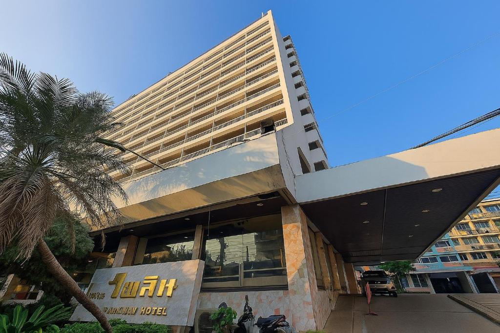 a building with a palm tree in front of it at Pailyn Hotel Phitsanulok in Phitsanulok