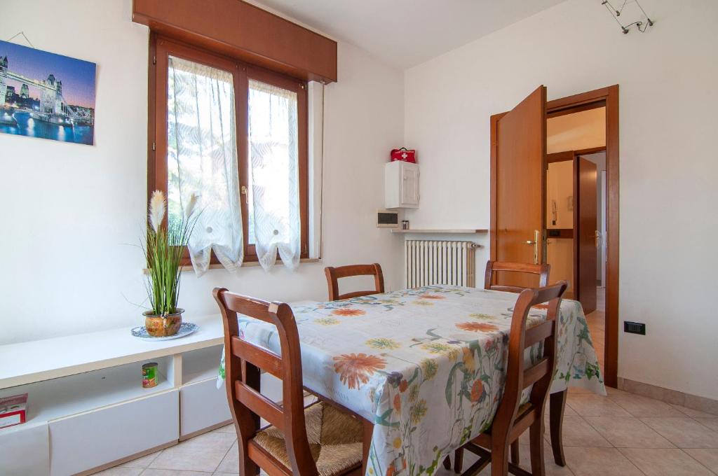 a dining room with a table and chairs and a kitchen at Emi&Marti House in Mozzecane