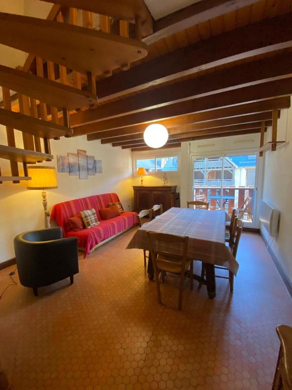 a living room with a red couch and a table at Appartement spacieux en duplex in Saint-Lary-Soulan