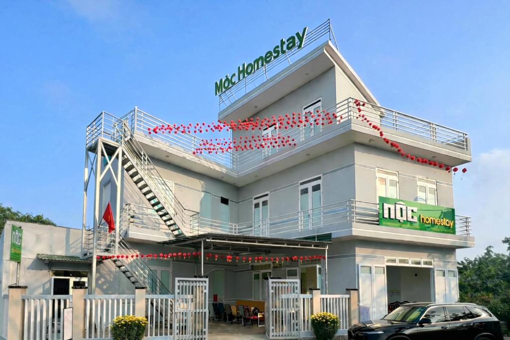 a building with a car parked in front of it at Mộc Homestay in Quảng Ngãi