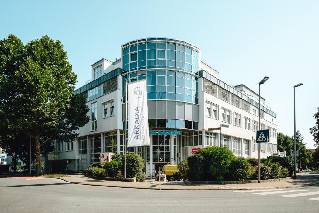 a large building with a sign in front of it at Hotel Arkadia in Friedrichsdorf
