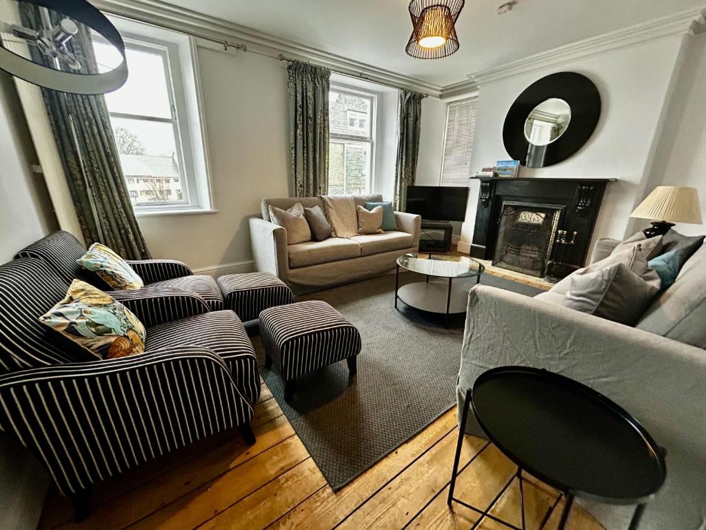 a living room with a couch and chairs and a fireplace at 3 The Townhouse in Keswick